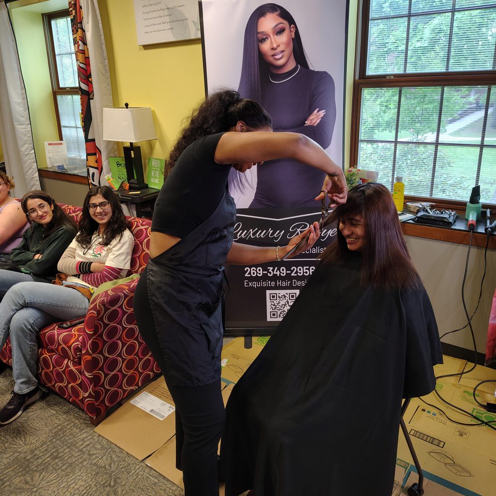 young woman getting hair cut at Intercultural Center Event